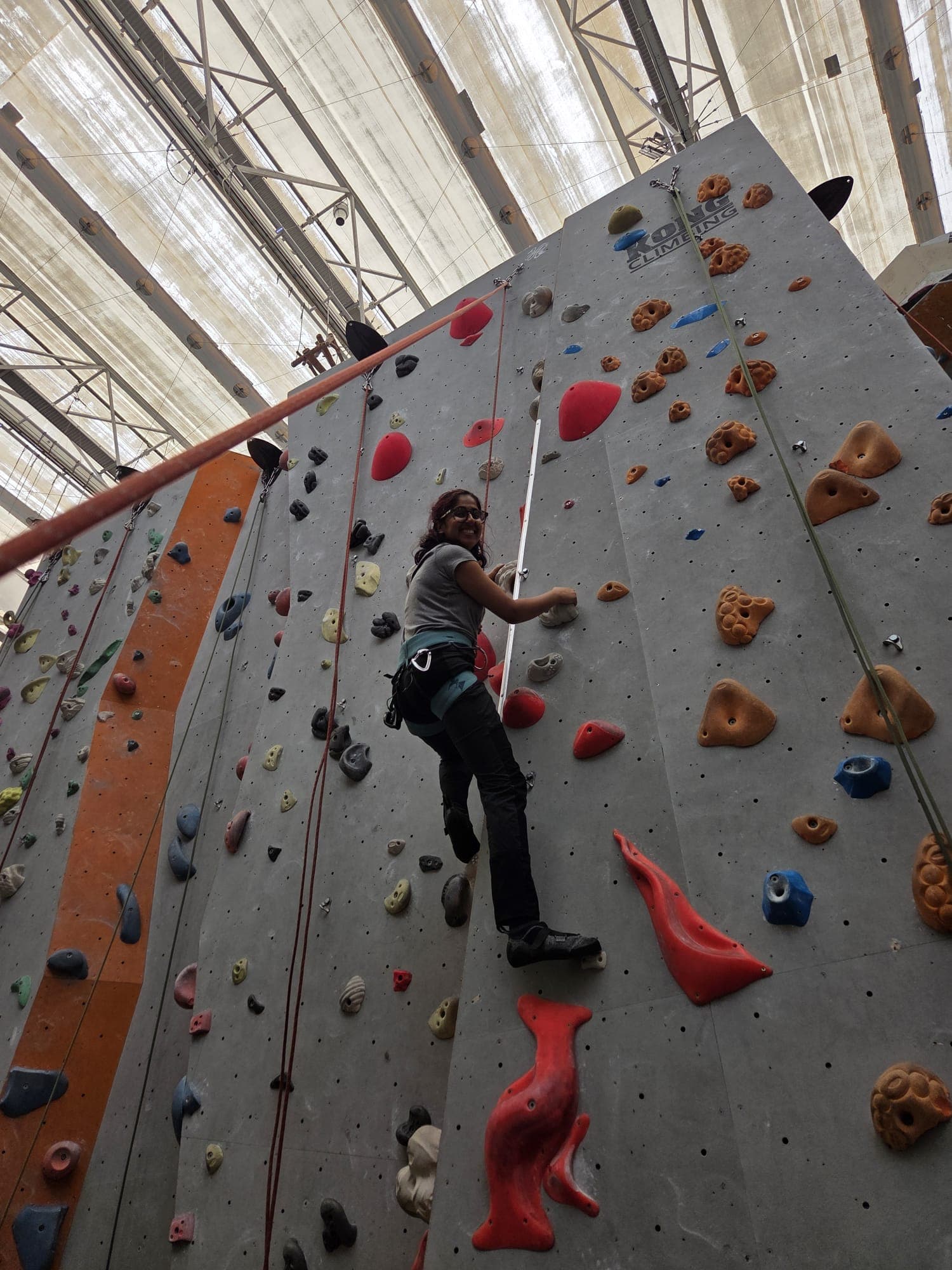 Shruti climbing at an indoor climbing wall
