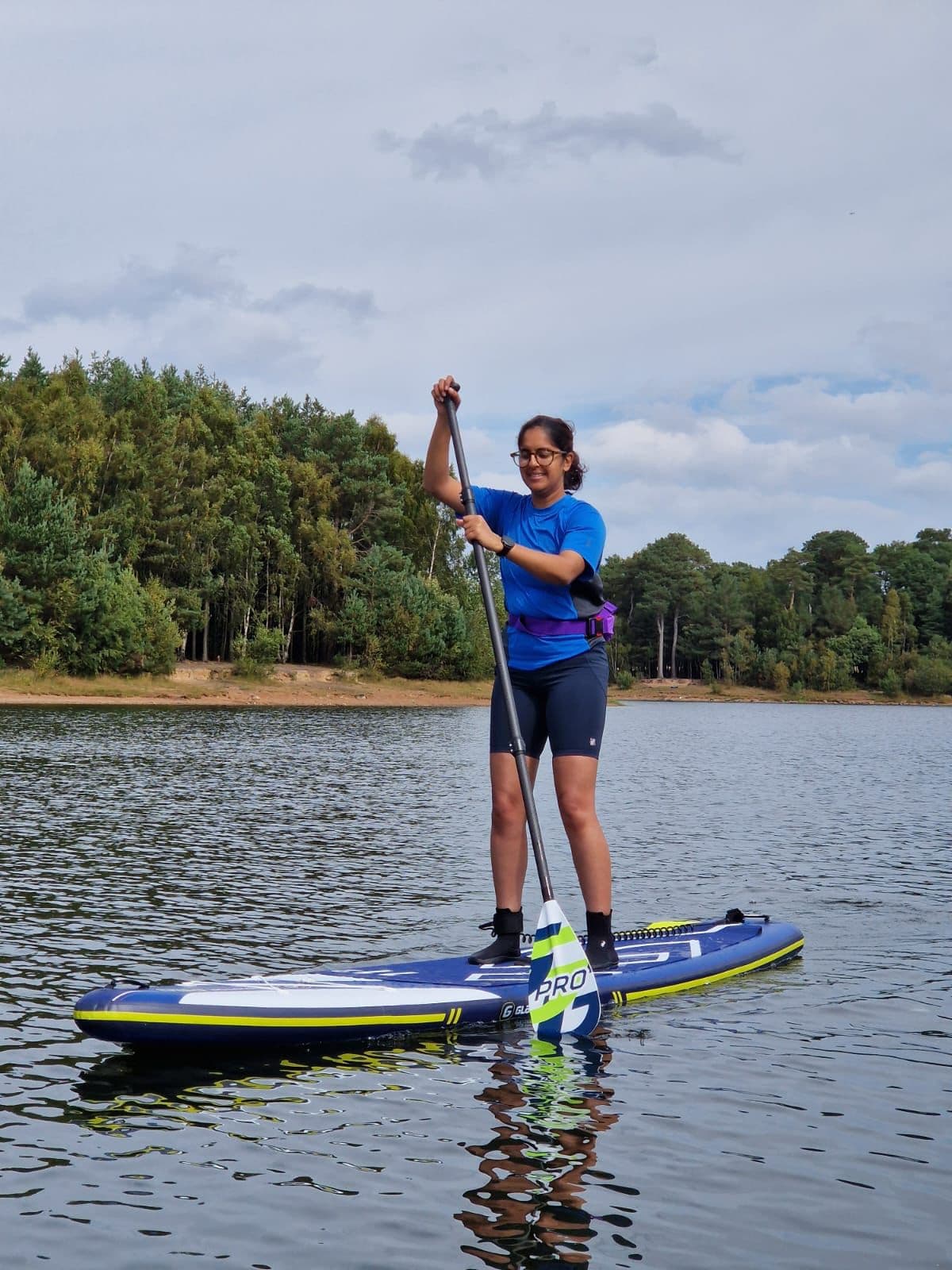 Shruti Turner paddleboarding on a lake
