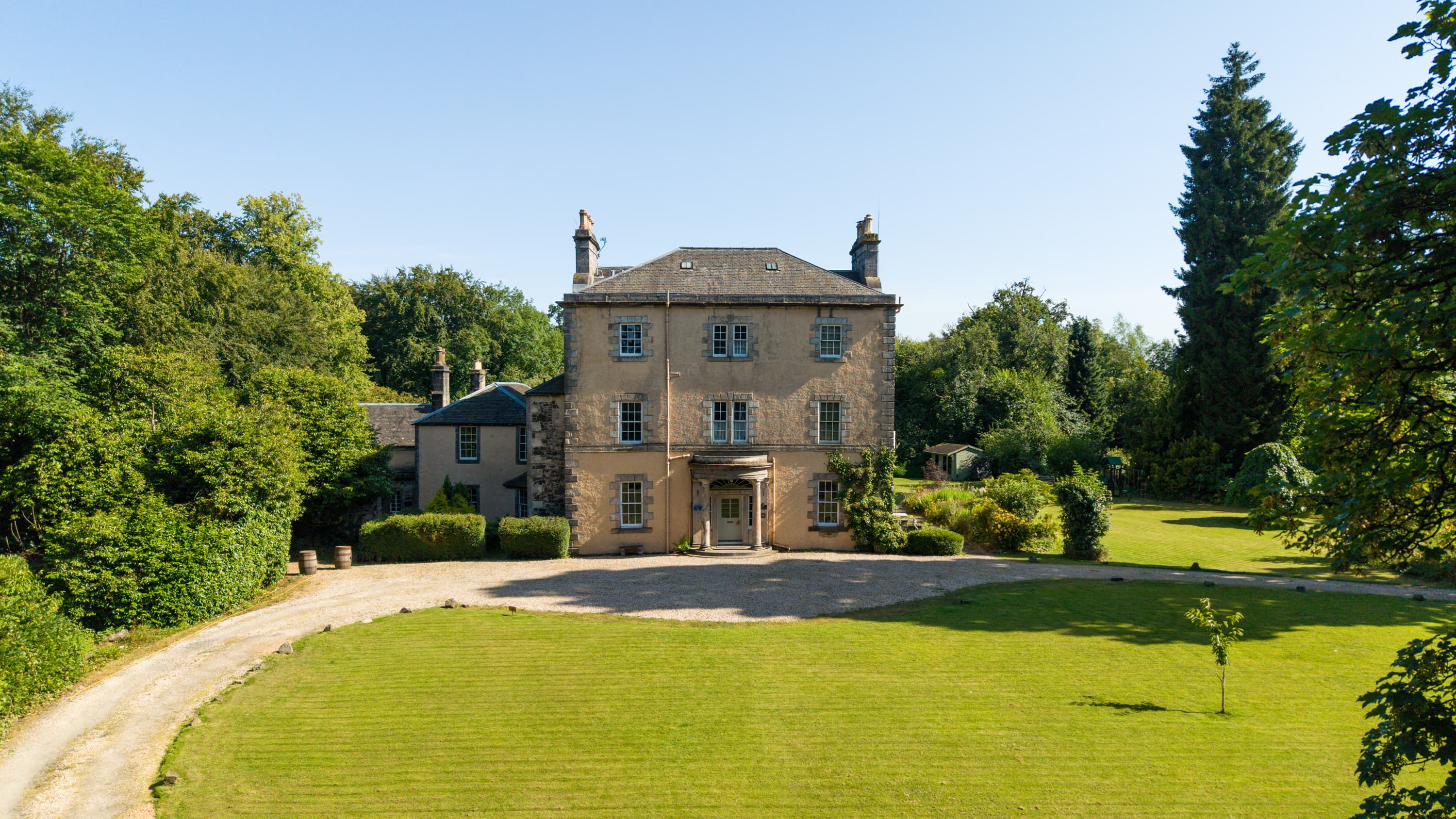 Powis House - photo of the front of the main building and the driveway. Clear blue sky.